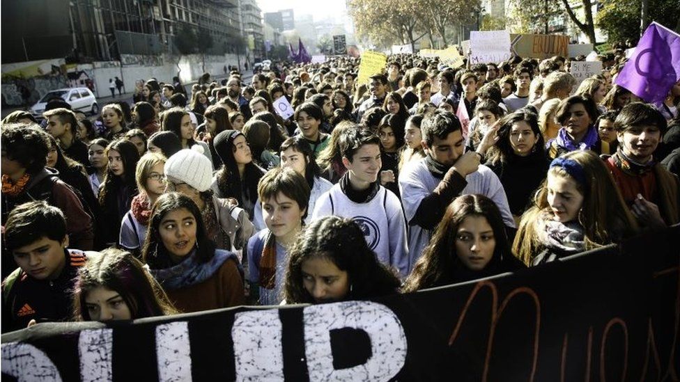 Schoolchildren can be seen taking part in a march against sexism in Santiago