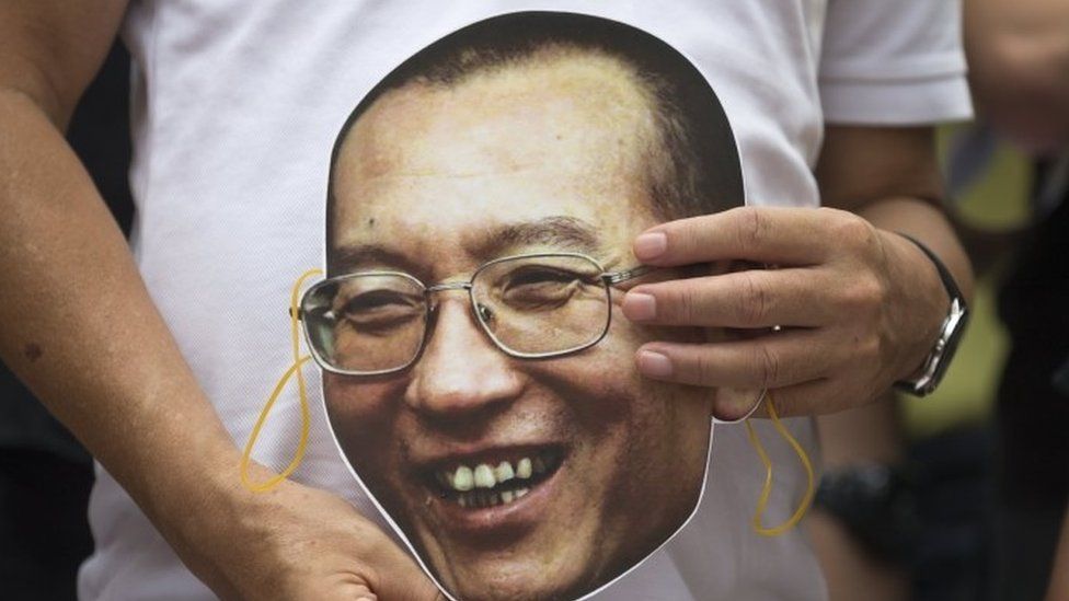 Protesters holds a mask with the face of Chinese dissident and Nobel laureate Liu Xiaobo during a protest outside the China Liaison Office in Hong Kong (27 June 2017)