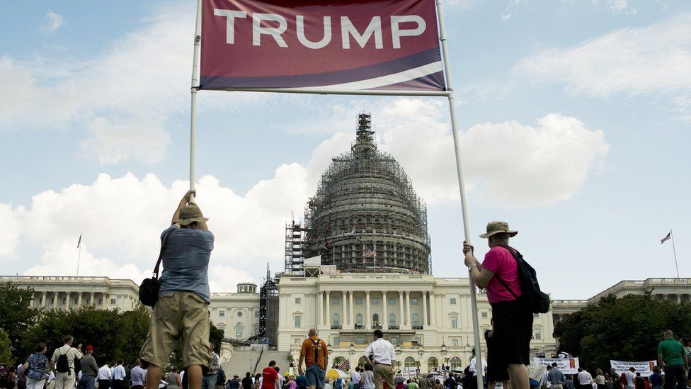 Trump supporters hold up a sign by the Capitol in Washington, DC.