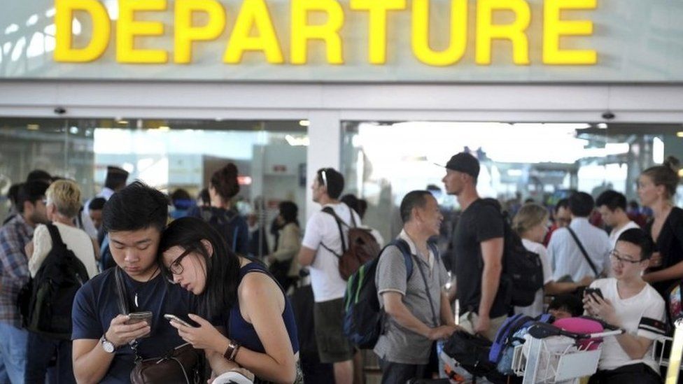 Passengers wait in the international terminal at Ngurah Rai airport in Denpasar