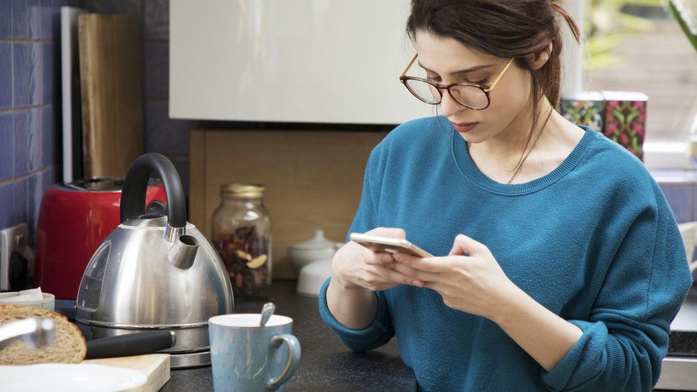 Woman boils kettle