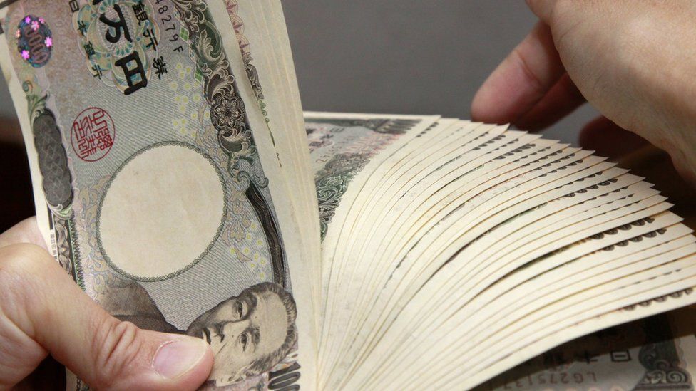 A bank teller counting 10,000 yen bank notes in Tokyo