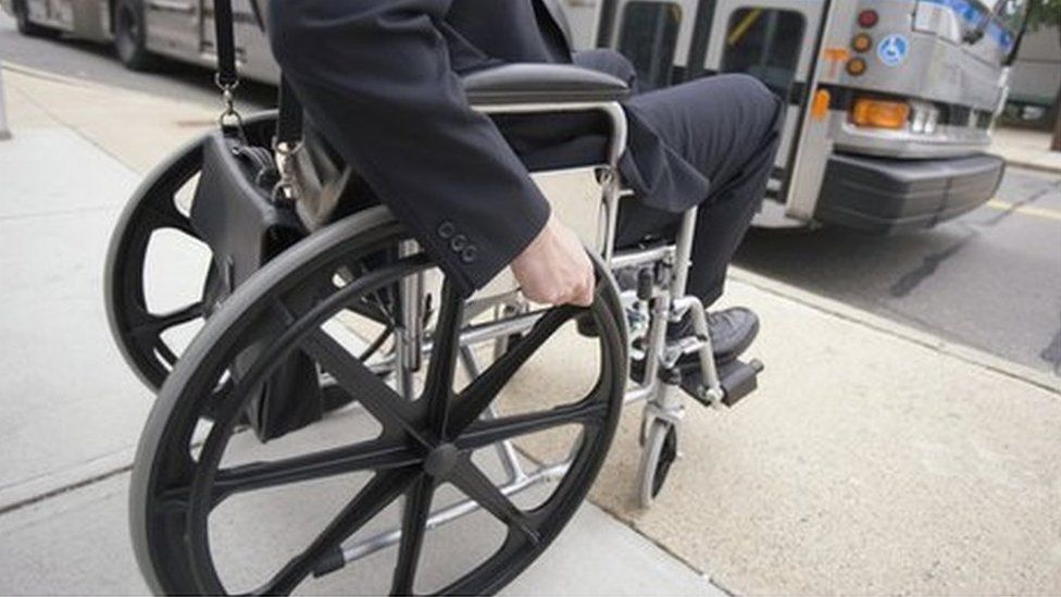Man in wheelchair waiting for a bus