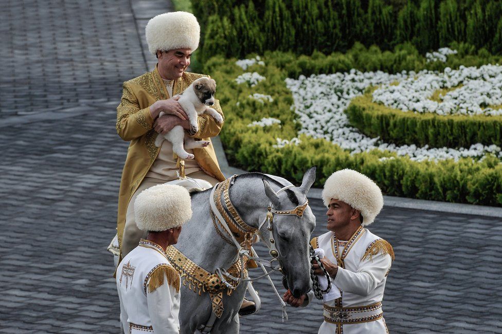 President Berdymukhamedov on a horse holding a puppy
