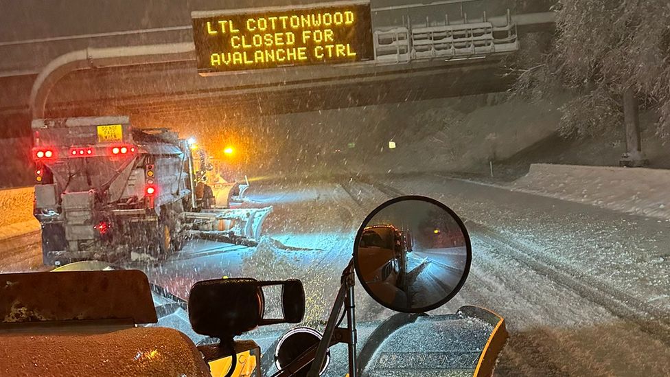 A snow plow travels down the I-215 in Utah