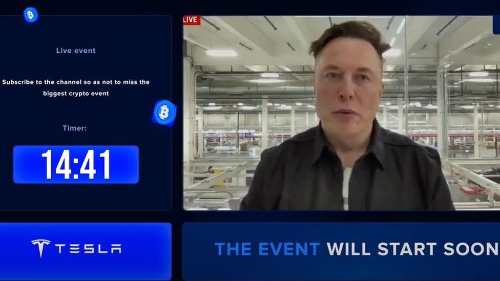 Кадр из видео на YouTube. На нем изображен Илон Маск вместе с такими текстами, как «событие скоро начнется» и «Tesla».