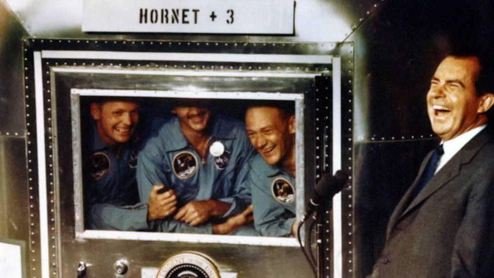 In this handout photo provided by the Richard Nixon Foundation, Apollo XI astronauts Neil Armstrong, Michael Collins and Buzz Aldrin laugh with President Richard Nixon aboard the USS Hornet, July 24, 1969.