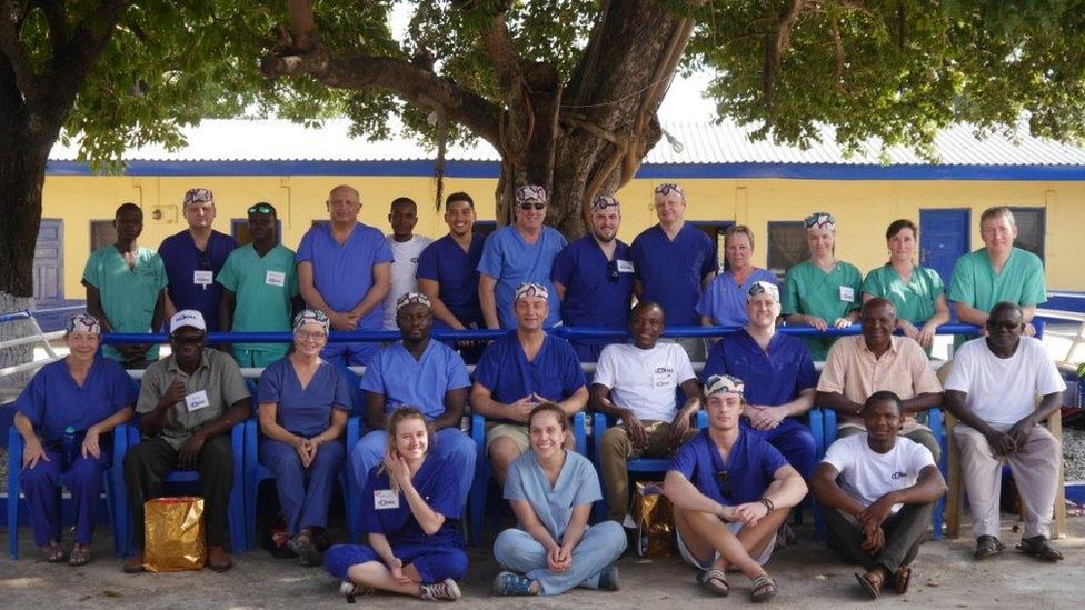 Group of people mainly in blue or green scrubs