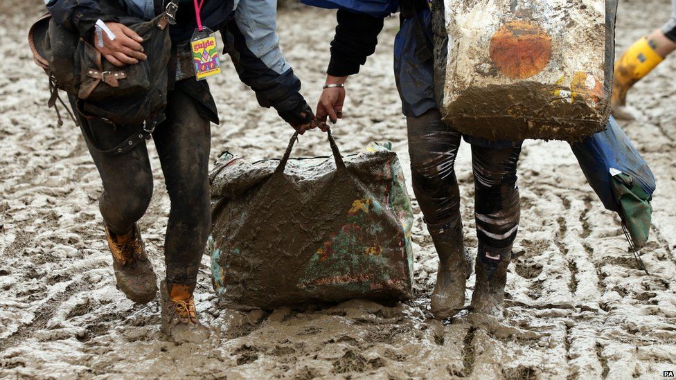 People dragging a bag through the mud