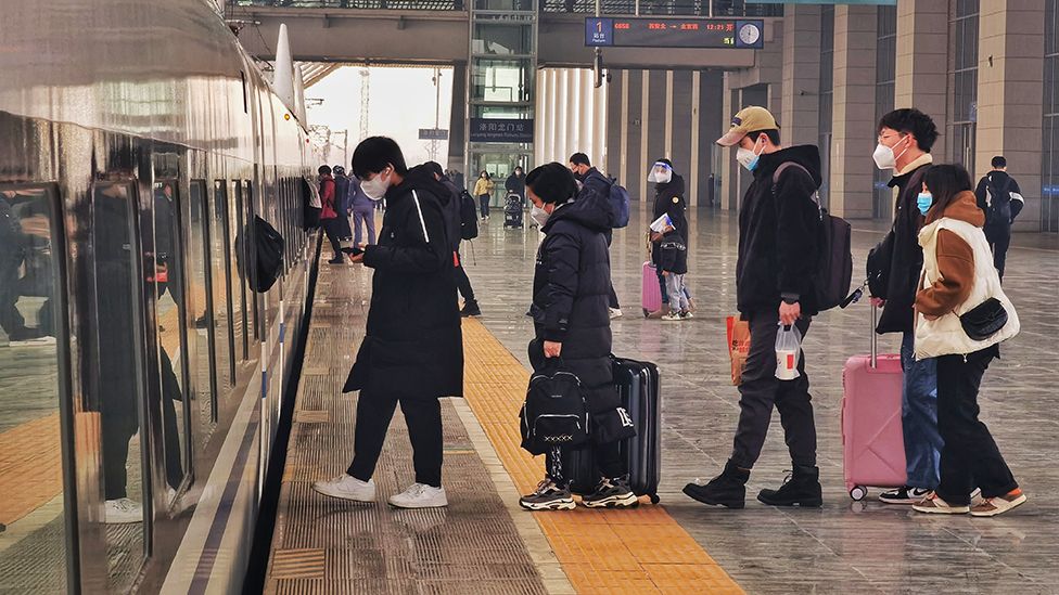 Пассажиры ждут в очереди, чтобы сесть на поезд на железнодорожной станции Лоян Лунмэнь в последний день новогодних праздников 2 января 2023 года в Лояне, провинция Хэнань, Китай