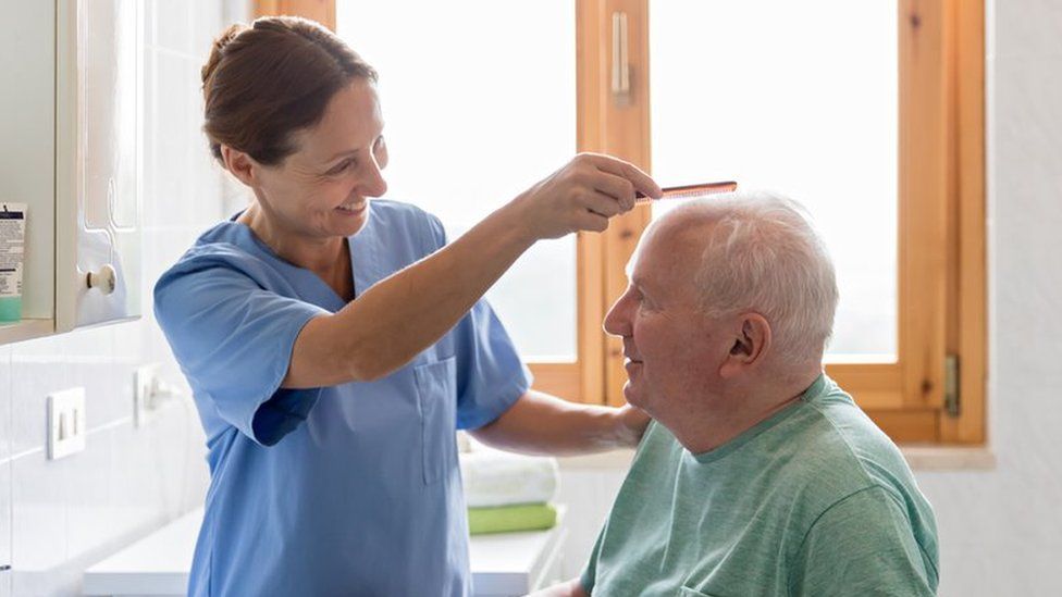 Home Caregiver with senior man in bathroom - stock photo