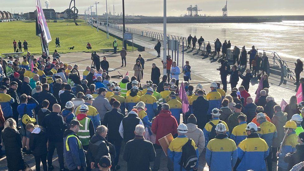 Protestors bow their heads during a march at Aberavon in Port Talbot