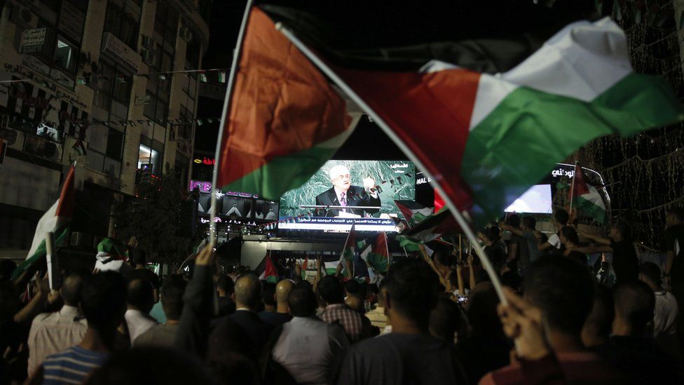 Palestinians watch Mahmoud Abbas address the UN General Assembly on a big screen in Ramallah (30 September 2015)
