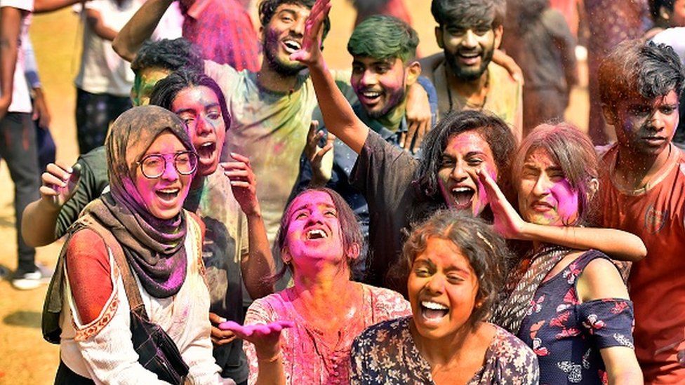 Students play with colours on the eve of Holi festival, at Shankar Lal Ground of Delhi University, on March 17, 2022 in New Delhi, India.