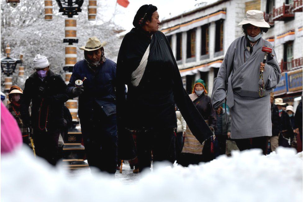 People walk on the Barkhor street after a snowfall on December 8, 2023 in Lhasa, Tibet Autonomous Region of China.