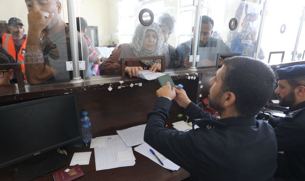 People showing their passports at the Rafah crossing