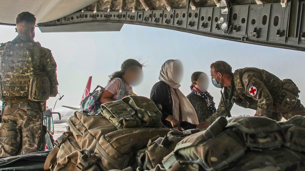 UK troops help Afghan nationals board an RAF plane in Kabul