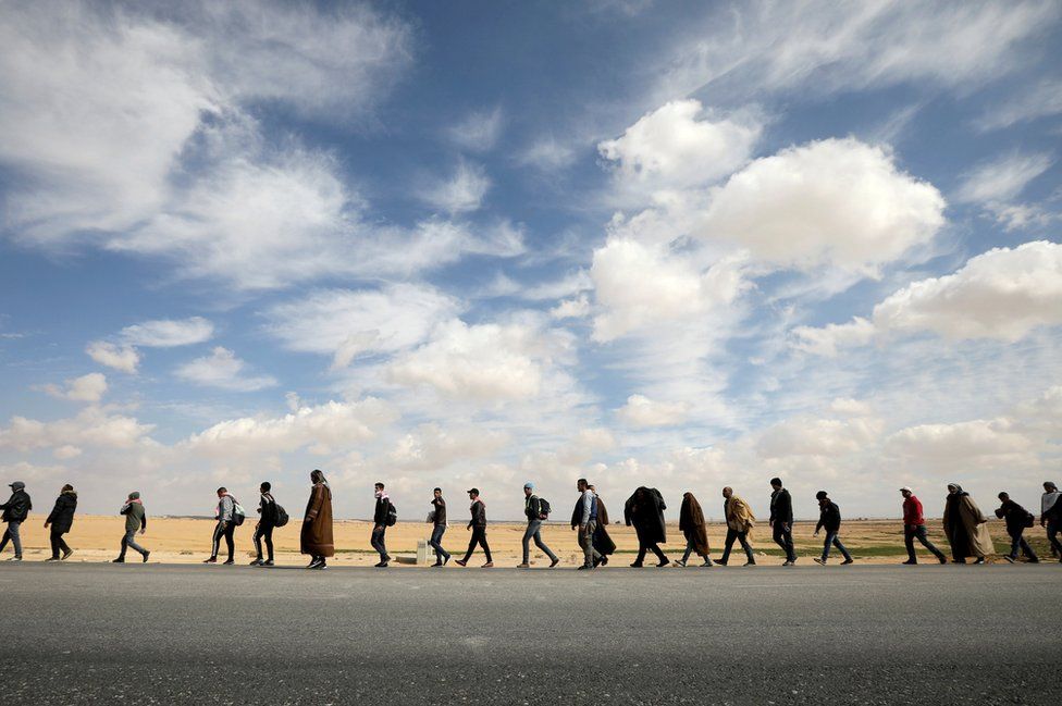 People walk during a march from the city of Aqaba south of the capital, demanding more employment opportunities, on the highway near Amman, Jordan, 20 February 2019