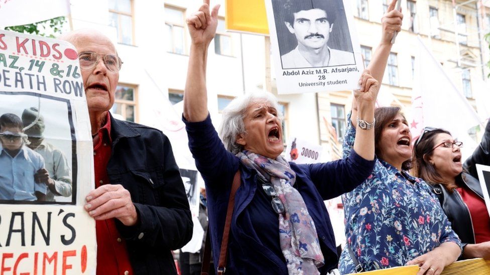 Protesters chant outside the court in Stockholm