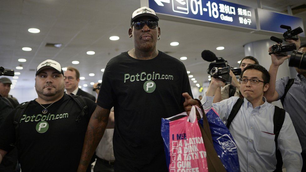 Former NBA basketball player Dennis Rodman of the US gestures as he arrives to check-in for his flight to North Korea at Beijing"s international airport on June 13, 2017.