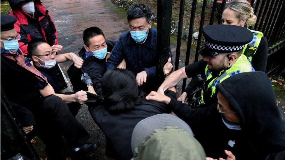 A man is pulled at the gate of the Chinese consulate after a demonstration against China"s President Xi Jinping, in Manchester, Britain October 16, 2022.