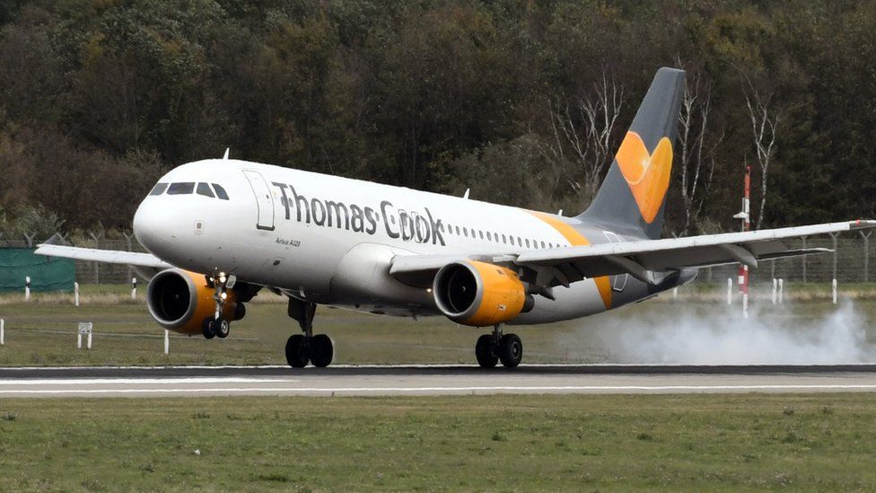 A Thomas Cook plane touches down on a runway.