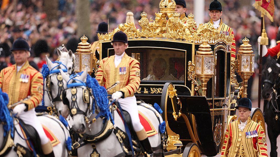 The King and Queen travelled in the Gold State Coach, led by horses dressed with magnificent blue plumes