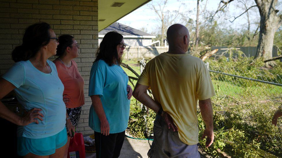 Debbie Darscheid and her family survey the damage at their house after Hurricane Laura passed through Lake Charles, Louisiana, 27 August