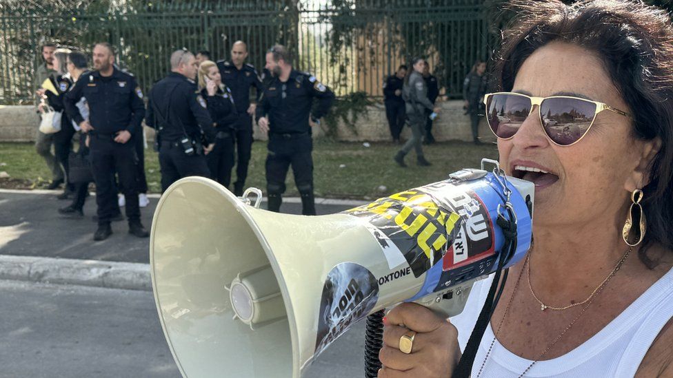 An Israeli protester holding a megaphone