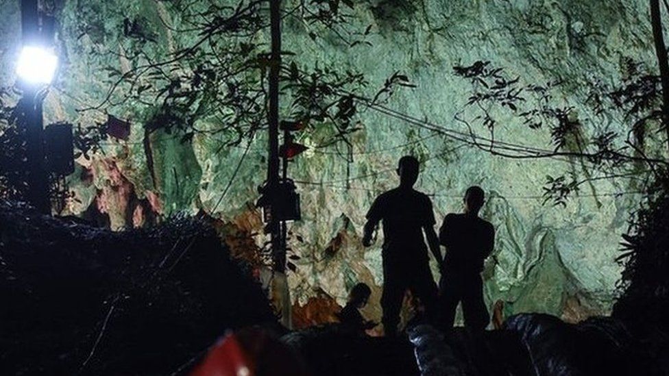 Thai soldiers stand at the mouth of Tham Luang cave