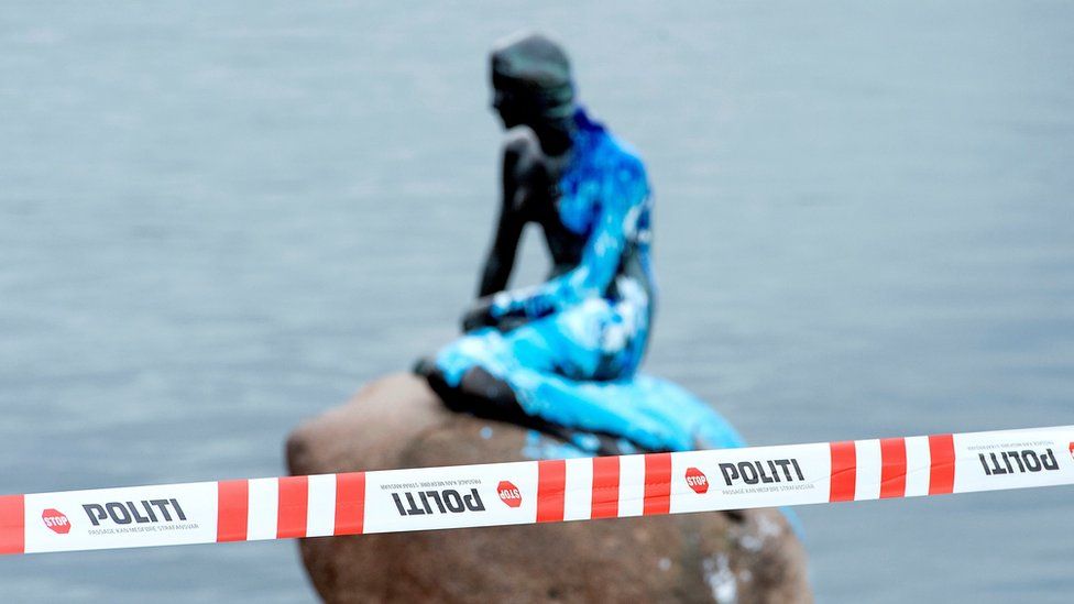 Police tape blocks off the Little Mermaid statue, covered in blue paint