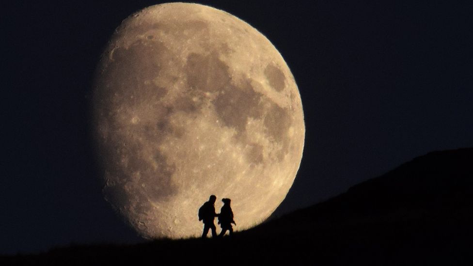 Couple silhouetted by the moon