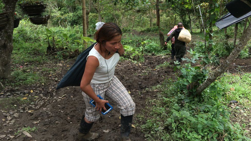Farc rebels carrying bags scamper up and down the hillside