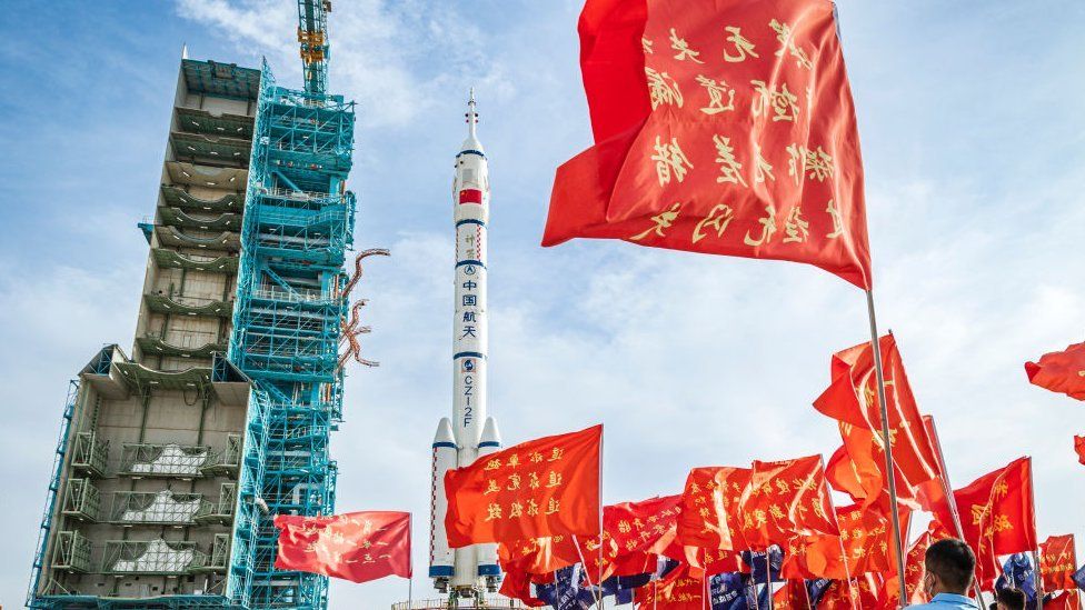 Red flags flying in front of the Chinese rocket