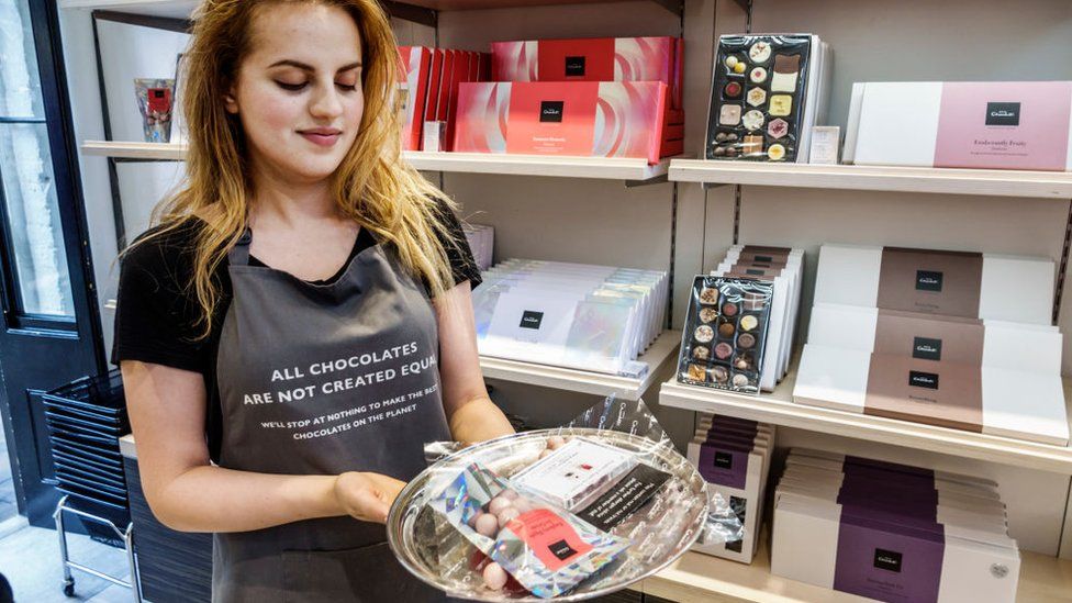 Hotel Chocolat store worker holding free samples