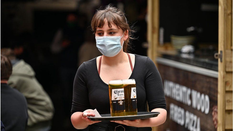 A waitress in a face mask
