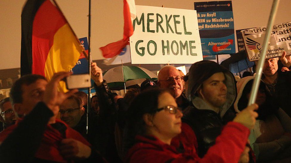Сторонники политической партии АдГ протестуют против либеральной политики канцлера Германии Ангелы Меркель в отношении приема мигрантов и беженцев