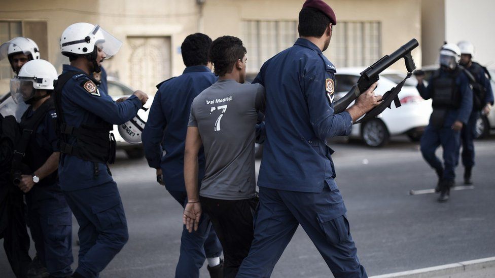 Bahrain riot policemen arrest a protester during clashes on 23 May 2015 in a village west of Manama