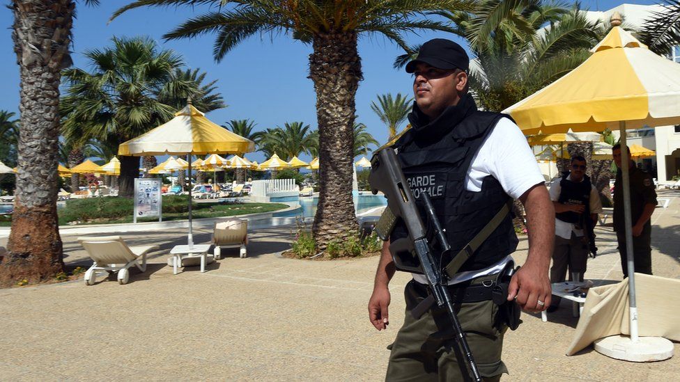 A Tunisian security member stands next to a swimming pool at the resort town of Sousse 26 June 2015