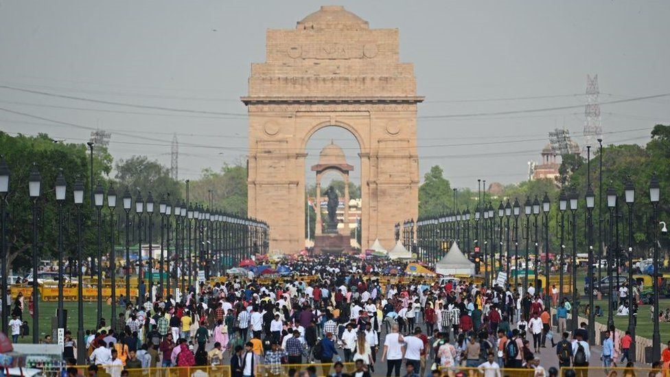 People crowd as they visit the India Gate in New Delhi on April 23, 2023