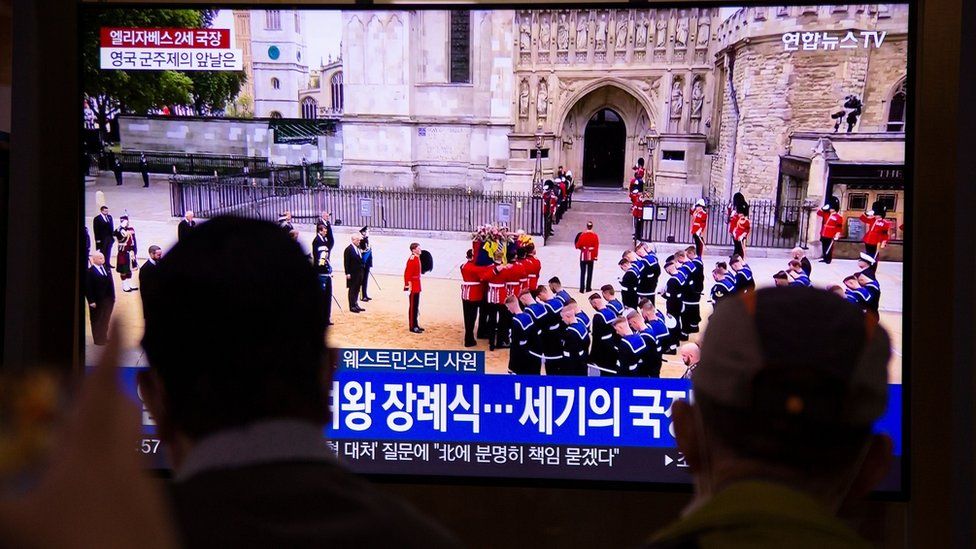 People at a station in Seoul, South Korea, watch a television broadcast of the State Funeral Procession of Queen Elizabeth II.