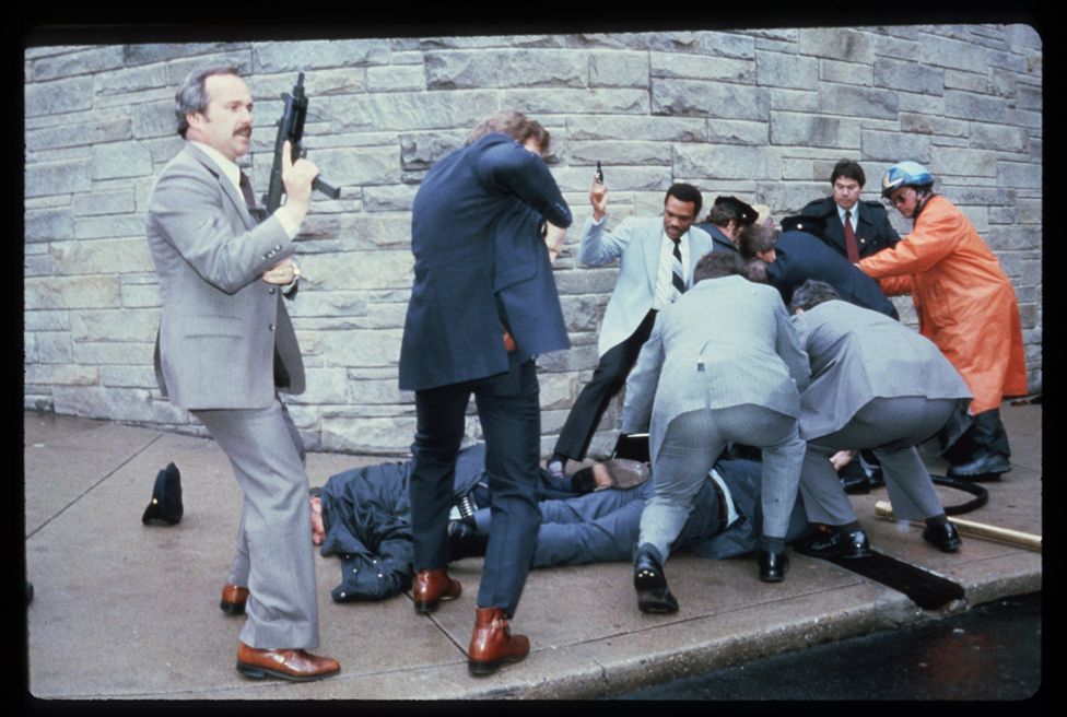 Chaos surrounds shooting victims immediately after the assassination attempt on President Reagan, March 30, 1981, by John Hinkley Jr. outside the Hilton Hotel in Washington, DC. Injured in the shooting are Press Secretary James Brady and Agent Timothy McCarthy.