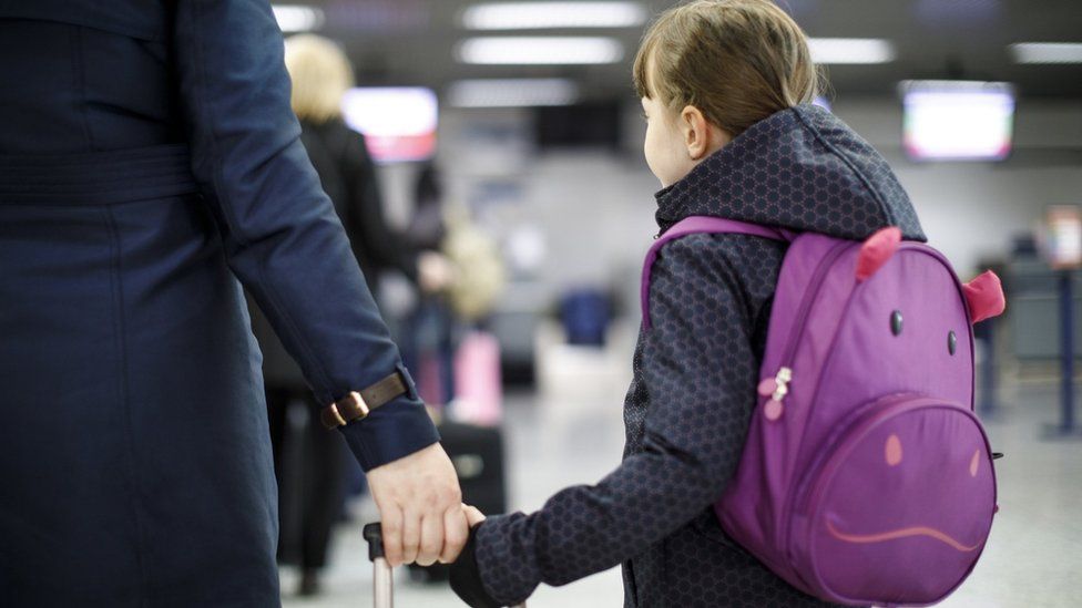 child with suitcase at airport