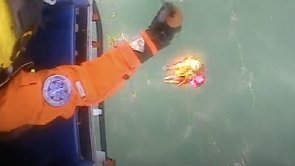 Swimmer being pulled out of the water through a helicopter rescue