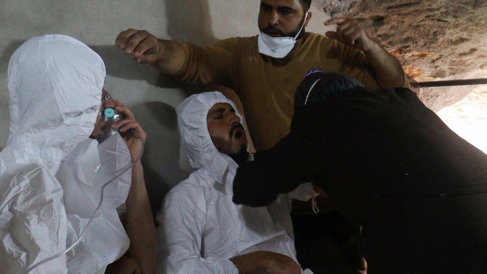 A man breathes through an oxygen mask as another one receives treatment after what rescue workers described as a suspected chemical attack in the town of Khan Sheikhoun in rebel-held Idlib province, Syria (4 April 2017)