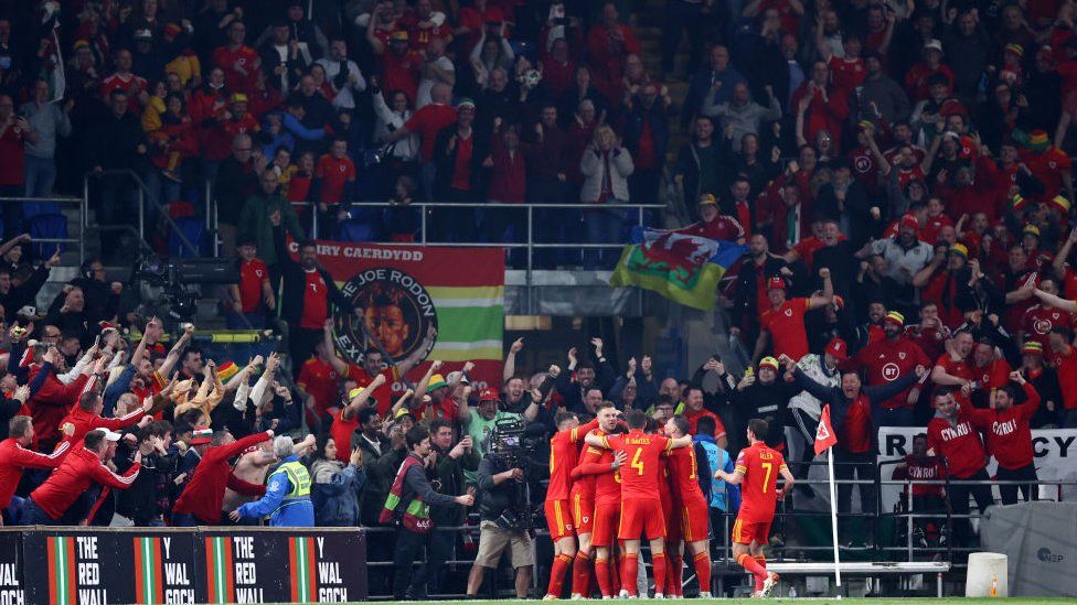 Jogadores do País de Gales comemoram na frente de seus fãs