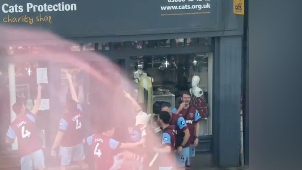 A video still of the group outside the charity shop