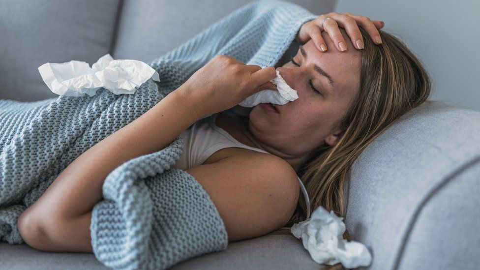 Women ill at home on the sofa with flu