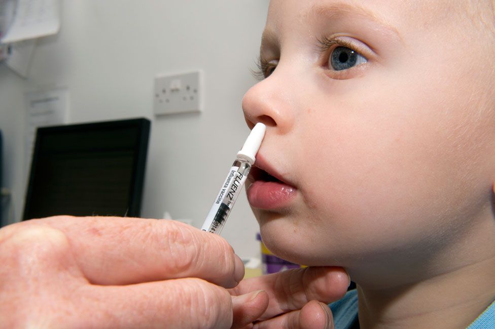 A young boy receiving the nasal-spray flu vaccine