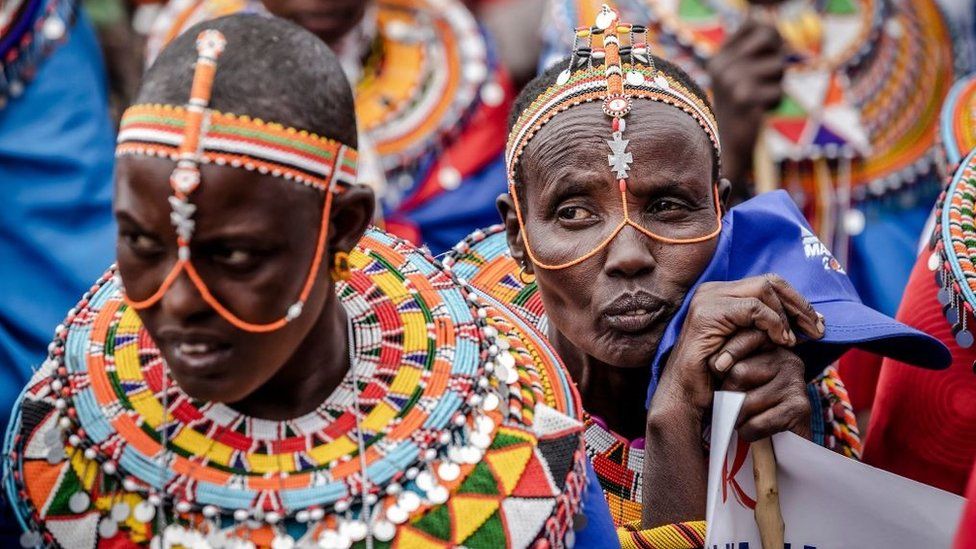 A Samburu woman and Azimio La Umoja (One Kenya Coalition Party) supporters listen to presidential candidate Raila Odinga during a campaign rally in Suswa Grounds, Narok, Kenya on July 30, 2022, ahead of Kenya's general election